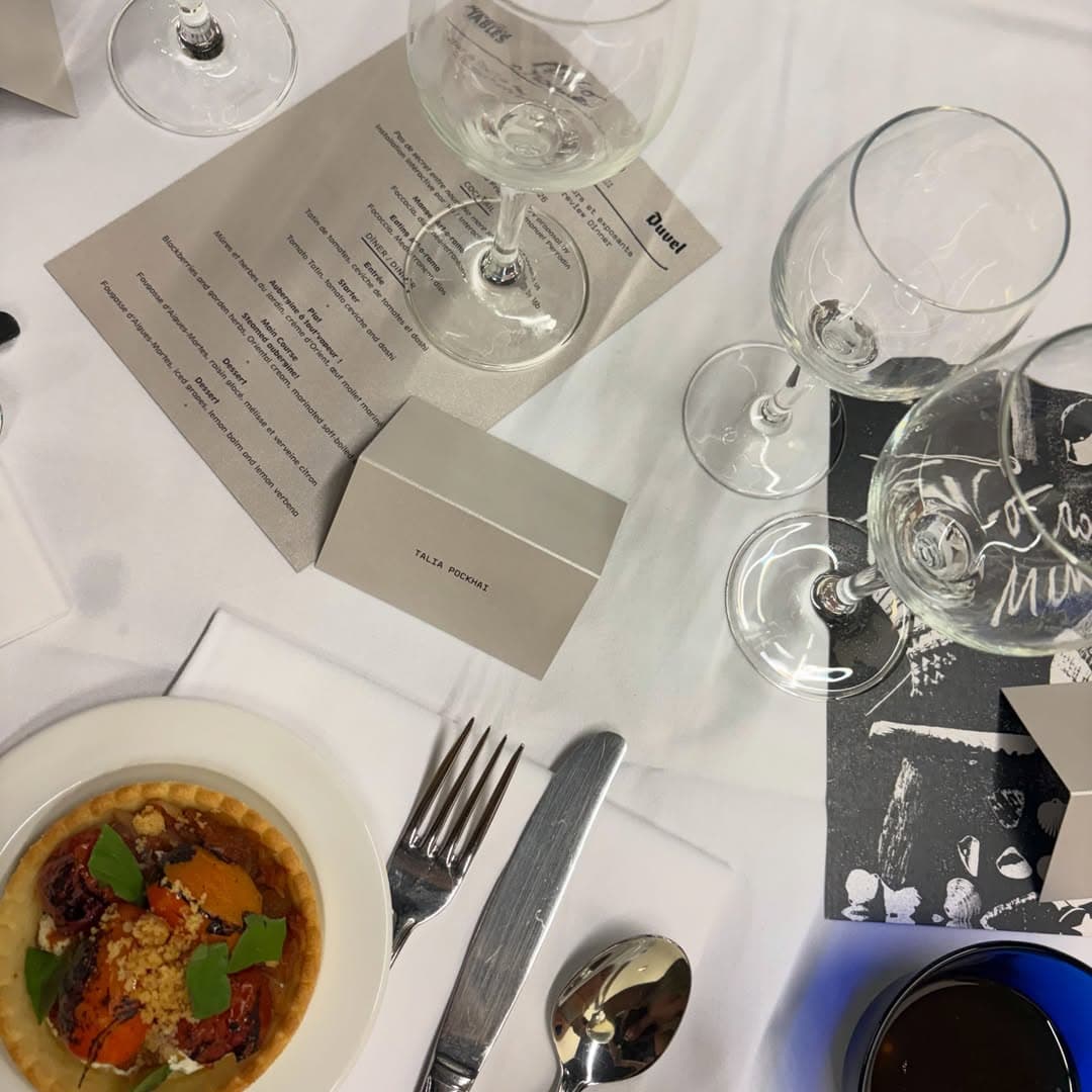 A dinner place setting with a menu and place card