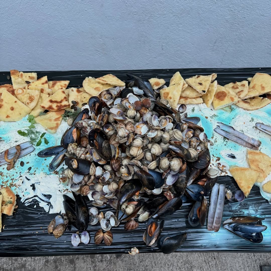 Mussels, clams and flatbread on a long black table