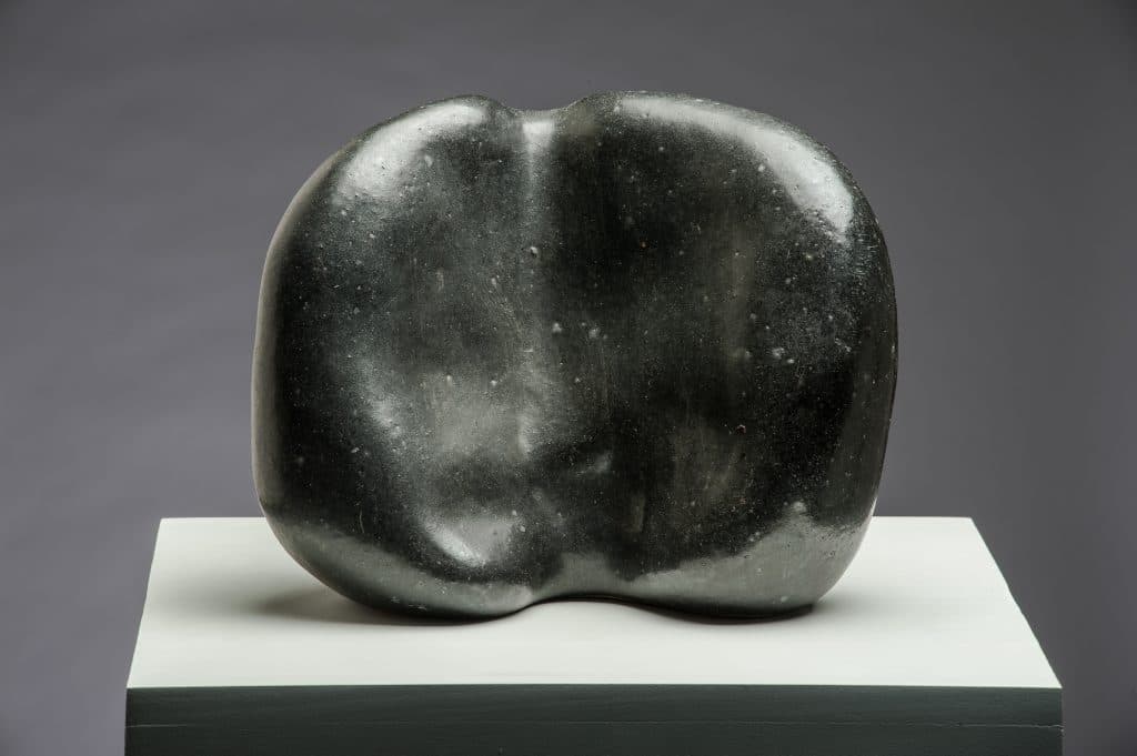 A black sphere and a white column in a corner