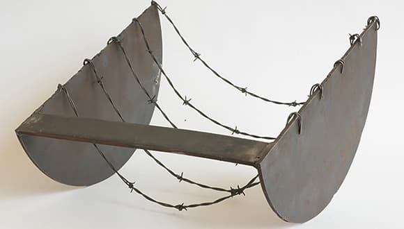 a large metal kinetic sculpture with barbed wire